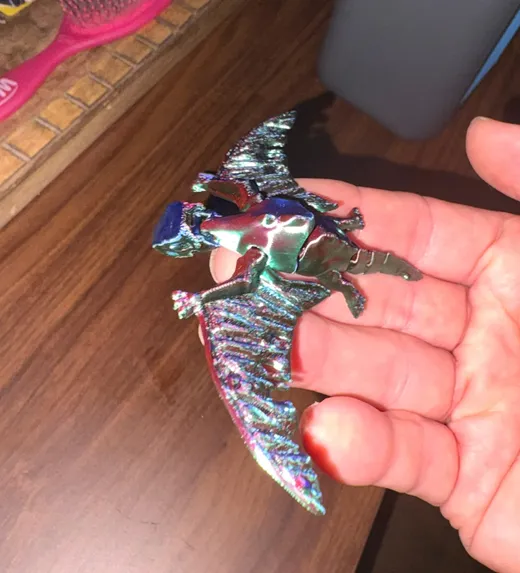 Articulated pterodactyl 3D print with spread wings resting in an open hand